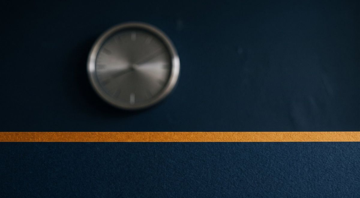 A softly blurred analog clock face behind a sharp horizontal amber line bisecting the frame.